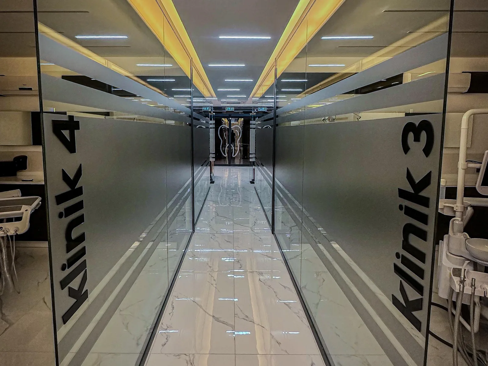 Clinic corridor opening to glass-partitioned treatment rooms