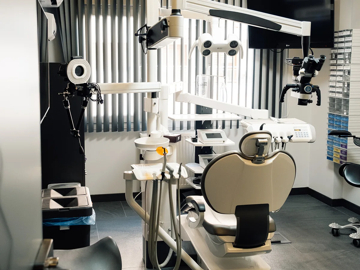 Practice treatment room with dental chair, microscope and clinical equipment